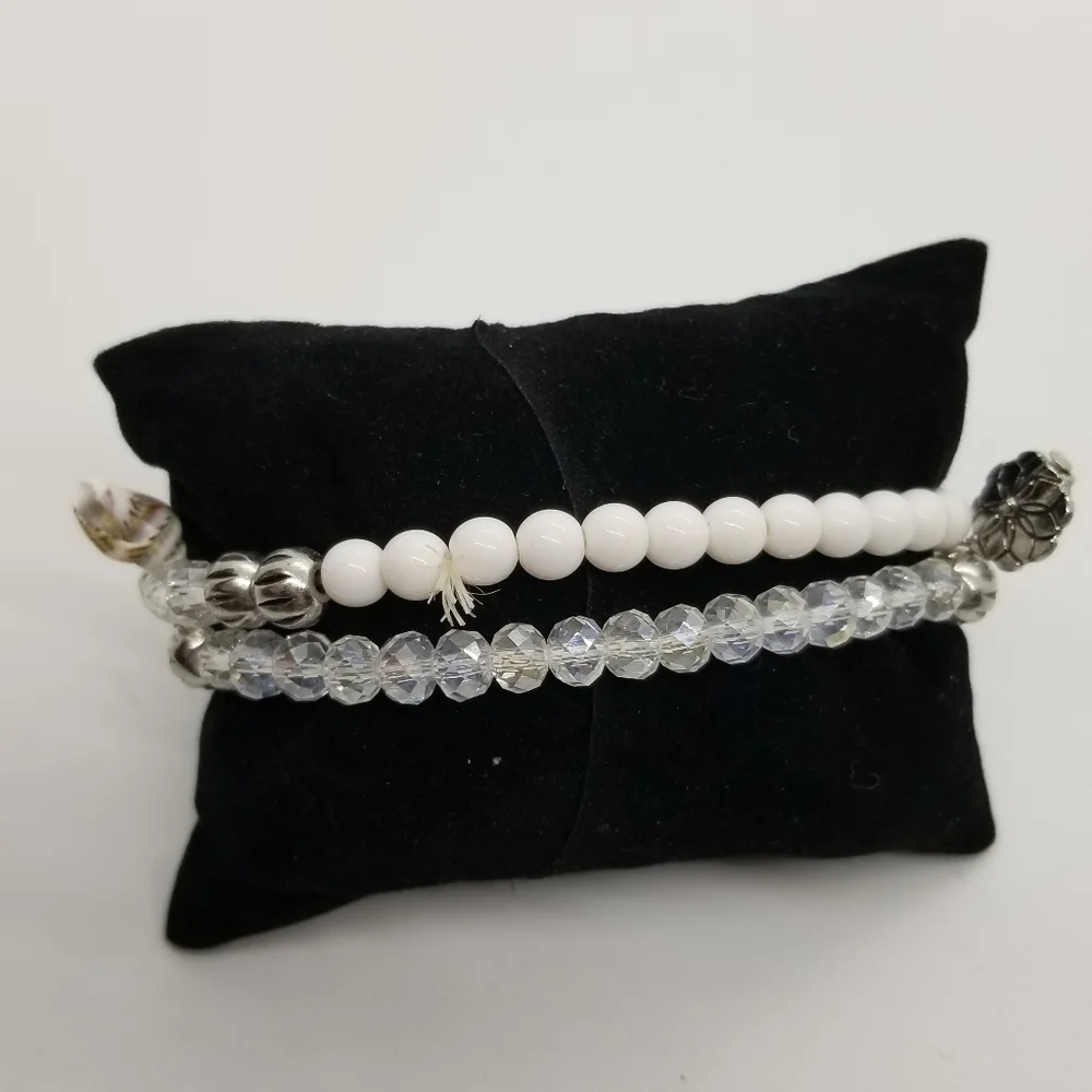 pair of white and clear stretch bracelets with shell charms